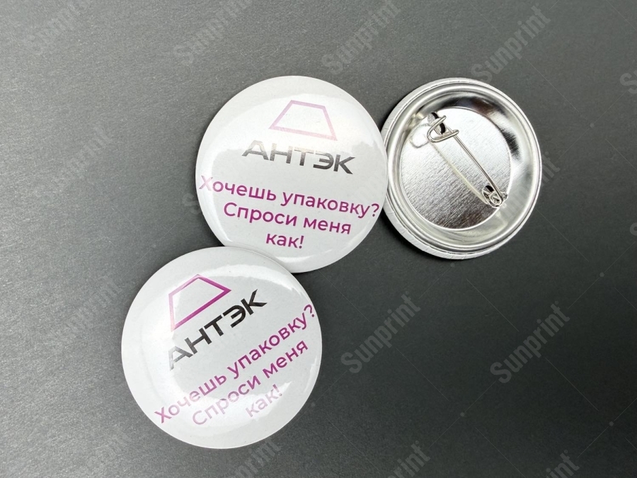 Закатные значки АНТЭК: лицевая сторона с защитной плёнкой и оборот с булавкой
