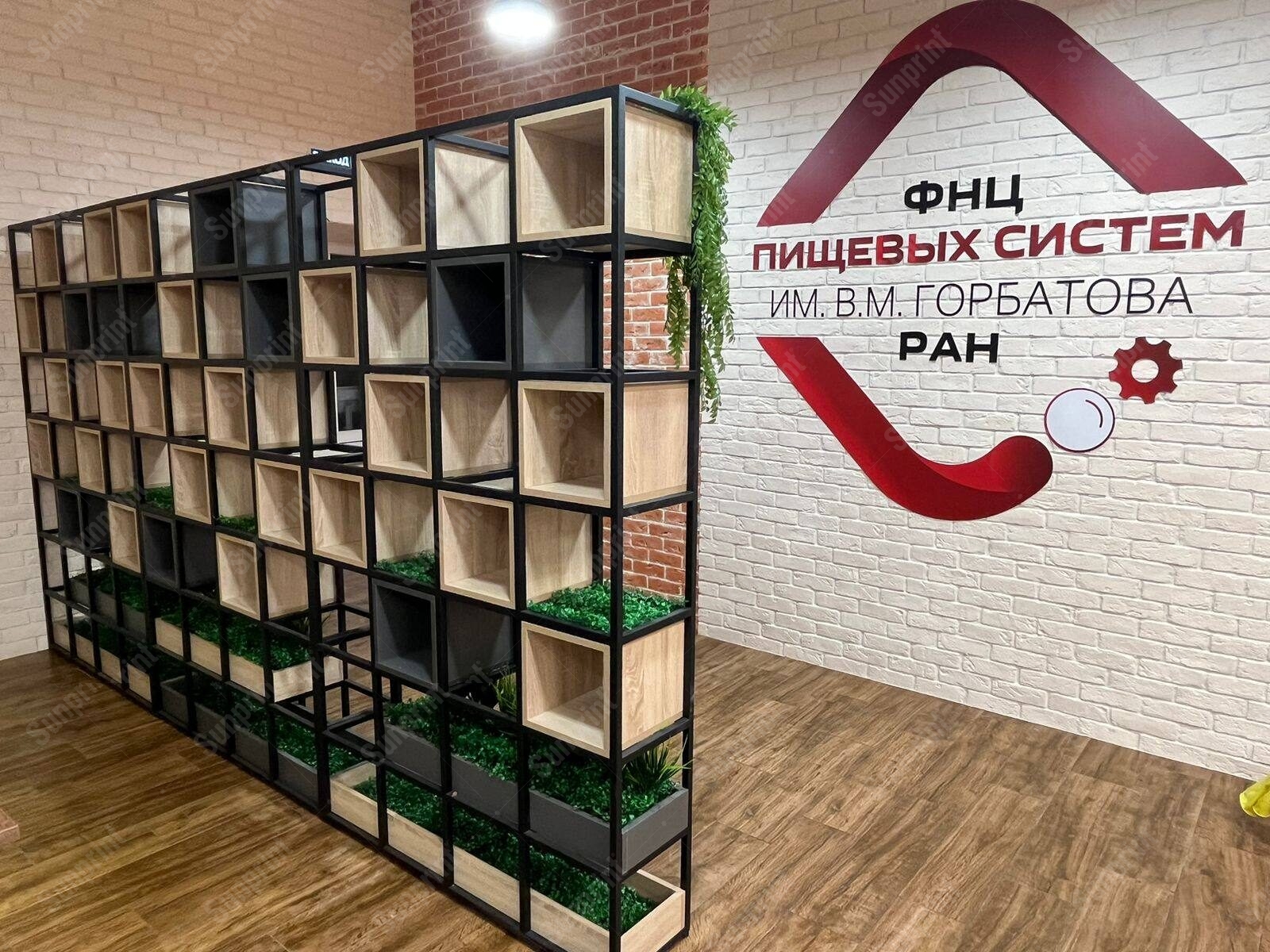 Логотип из плоттерной резки на кирпичной стене — интерьерное брендирование